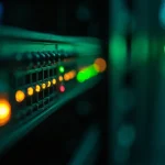Server rack panel with a single amber warning light among green ones